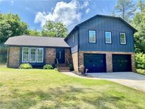 Beautiful two-story brick and blue home with a well-manicured front lawn and attached two-car garage at 323 W Claiborne Ct, Marietta, GA 30066