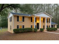 Charming two-story home featuring a columned porch, black shutters, and a well-maintained front lawn at 1607 Hillview, Jonesboro, GA 30236
