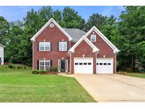 Charming two-story brick home featuring a well-manicured lawn and a two-car garage at 2994 Meadow Church Rd, Suwanee, GA 30024