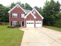 Charming brick home with a two-car garage, manicured lawn, and classic design at 2994 Meadow Church Rd, Suwanee, GA 30024