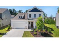 Beautiful two-story home with a manicured lawn, attached garage and lovely front porch at 803 Levi Farms Ln, Canton, GA 30115