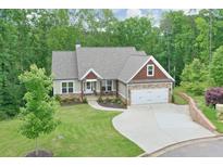 Charming single-Gathering home with a well-manicured lawn, two car garage, and inviting covered porch nestled among mature trees at 10 Berryhill Se Pl, Cartersville, GA 30121