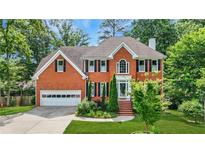 Beautiful two-story brick home with lush landscaping and a well-manicured lawn at 2641 Loch Way, Snellville, GA 30039