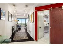 Bright hallway featuring hardwood floors, modern lighting fixtures, and a decorative sliding door at 2660 Peachtree Nw Rd # 13H, Atlanta, GA 30305