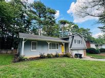 Charming home with a well-maintained front lawn and inviting curb appeal, featuring a bright yellow front door at 3210 Ebenezer Rd, Marietta, GA 30066