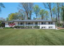 Charming single-story home featuring a manicured lawn, white painted brick, and a welcoming front porch at 380 Atwood Nw Dr, Marietta, GA 30064