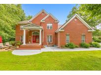 Stunning red brick home featuring a manicured lawn and inviting front porch with stately columns at 915 Chipley Ct, Marietta, GA 30062