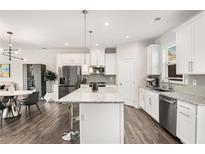 Bright, open kitchen boasts stainless appliances, gray wood floors, and a center island with granite countertop at 1590 Ridgebrook Downs, Mableton, GA 30126