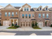 Charming townhomes featuring brick exteriors, well-manicured lawns, and attached two-car garages at 1590 Ridgebrook Downs, Mableton, GA 30126
