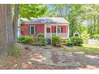 Charming single-story home with a red exterior, inviting front porch, and lovely landscaped front yard at 350 Pleasant Oak Sw Ct, Marietta, GA 30008