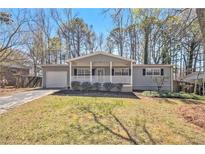 Charming single-story home featuring a welcoming front porch, attached garage, and cozy curb appeal at 1602 Sycamore Nw Dr, Kennesaw, GA 30152