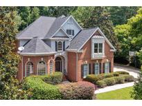 Beautiful two-story brick home with lush landscaping and a well-manicured front yard at 4567 Brigade Ne Ct, Roswell, GA 30075