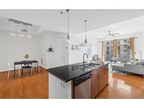 Bright, modern kitchen features stainless steel appliances, pendant lighting and an island with a sink at 711 Cosmopolitan Ne Dr # 300, Atlanta, GA 30324