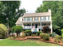 Charming two-story home with a covered front porch, green shutters, and a well-manicured front yard at 1935 Shrader Ct, Lawrenceville, GA 30044
