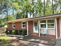 Charming brick ranch with a cozy front porch and mature trees at 877 Verona Dr, Clarkston, GA 30021