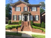 Charming brick home with black shutters, manicured landscaping, and inviting front steps at 962 Manor Parc Dr, Decatur, GA 30033
