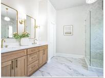 Bright bathroom featuring marble floors, dual sink vanity, and glass-enclosed shower at 1826 Terry Mill Se Rd, Atlanta, GA 30316