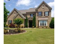 Beautiful brick home with a well-manicured lawn and landscaped flower beds at 6110 Read Rd, Suwanee, GA 30024