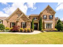 Charming two-story brick home with manicured lawn and well-maintained landscaping at 6110 Read Rd, Suwanee, GA 30024