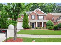 Charming two-story brick home with black shutters, a well-manicured lawn, and a two-car garage at 4087 Kingsley Park Ct, Peachtree Corners, GA 30096