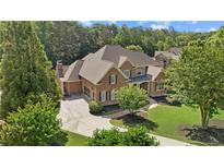 Stately brick home with lush landscaping, circular drive, and mature trees at 13037 Overlook Pass, Roswell, GA 30075