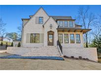 Charming two-story brick home with a well-manicured lawn, a covered porch, and elegant architectural details at 375 Chattahoochee St, Roswell, GA 30075