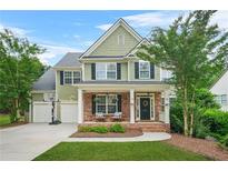 Charming two-story home with brick accents, covered porch, manicured lawn, and a two-car garage at 1037 Panoramic Pte, Buford, GA 30518