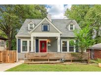 Charming two-story home with a gray exterior, red door, dormer windows and a well-manicured lawn at 1393 Westview Sw Dr, Atlanta, GA 30310