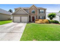 Charming two-story home featuring a two-car garage and lush, green lawn at 3235 Northcliff Dr, Suwanee, GA 30024