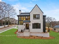 Stunning two-story home featuring a modern black-and-white facade and manicured landscaping at 56 Pine St, Roswell, GA 30075