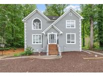 Charming two-story home with a gray stucco exterior and well-manicured front yard, steps leading to the front door at 959 Vendue Dr, Lawrenceville, GA 30044
