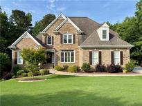 Charming brick home boasts a manicured lawn and mature landscaping at 102 Avalon Ct, Canton, GA 30115