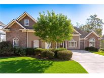 Charming single-Gathering home with a well-manicured lawn, mature trees, and a stone and siding exterior at 2041 Democracy Dr, Buford, GA 30519