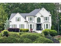 Charming white brick home with a manicured lawn and dark shutters, adding to the curb appeal at 310 Hillpine Dr, Woodstock, GA 30189