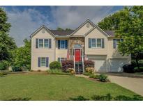 Charming two-story home with a well-manicured lawn and a pop of color from the red front door at 3870 Michaels Creek Ct, Loganville, GA 30052