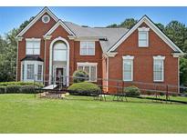 Spacious two-story brick home with a well-manicured lawn and attractive landscaping at 2892 Motts Cove Holw, Lawrenceville, GA 30043