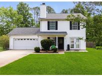 Charming two-story home featuring a well-manicured lawn, attached garage, and classic black shutters at 70 Fairclift Dr, Covington, GA 30016