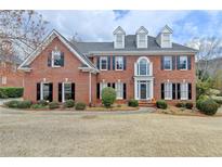 Beautiful two-story brick home featuring a well-manicured lawn and classic architectural details at 340 Kincardine Way, Alpharetta, GA 30022