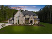 Beautiful two-story home featuring a well-manicured lawn and a blend of stone and painted brick at 2400 Worth Ave, Loganville, GA 30052