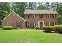 Beautiful two-story brick home featuring a well-manicured lawn and mature landscaping at 2101 Breconridge Sw Dr, Marietta, GA 30064
