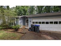 Quaint single Gathering home featuring a two-car garage and light blue vinyl siding at 345 Deerwood Dr, Suwanee, GA 30024