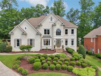 Charming two-story home with a lush front yard and manicured landscaping at 1225 Elk Ridge Cv, Alpharetta, GA 30005