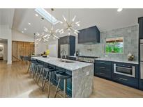 Modern kitchen featuring a large island with marble countertops, stainless steel appliances and stylish lighting fixtures at 2648 Varner Ne Dr, Atlanta, GA 30345