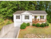 Charming home featuring a neatly landscaped front yard, a driveway, and a cozy front porch at 306 Birch St, Canton, GA 30114