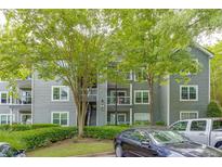 Exterior of the property featuring gray siding, balconies, and well-maintained landscaping and parking at 4106 Santa Fe Pkwy, Atlanta, GA 30350