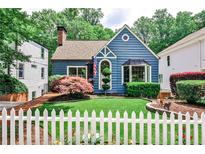 Charming blue two-story home with a manicured lawn, lovely landscaping, and a classic white picket fence at 2639 Acorn Ne Ave, Atlanta, GA 30305