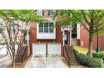 Charming brick townhome featuring a two-car garage and inviting entrance with landscaped surroundings at 5439 Alanis Se Pl # 17, Mableton, GA 30126
