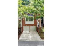 Charming brick townhome featuring a two-car garage and inviting front entrance with landscaped surroundings at 5439 Alanis Se Pl # 17, Mableton, GA 30126