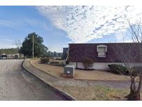 Cozy suburban townhome complex featuring neat landscaping under a partly cloudy sky at 152 Rue Fontaine, Lithonia, GA 30038