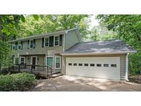 Charming two-story home with a two car garage and a welcoming front porch surrounded by lush greenery at 295 Lakemont Dr, Roswell, GA 30075